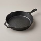 The Lodge skillet — black pebbled iron, short handle and helper handle