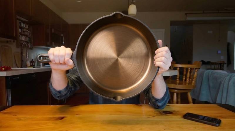 David in his kitchen holding the iLume skillet up to the camera, bronze interior facing out.